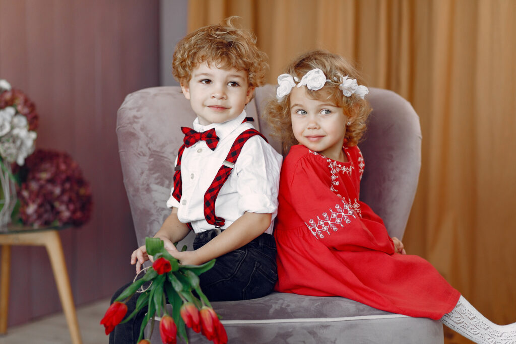 Elegant little kids in a studio with bouquet of tulip